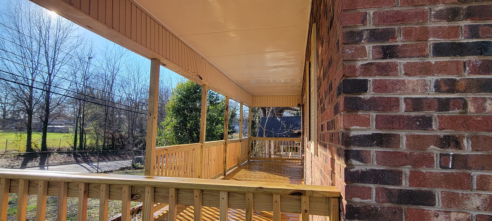 Long covered wooden porch with wet freshly cleaned planks